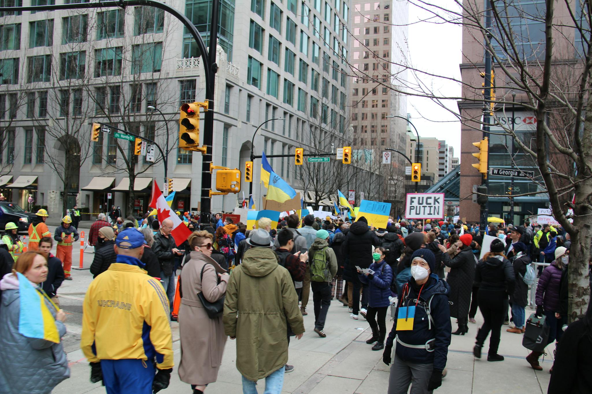 Crowd of protesters in downtown Vancouver advocating for Ukraine with flags and signs.